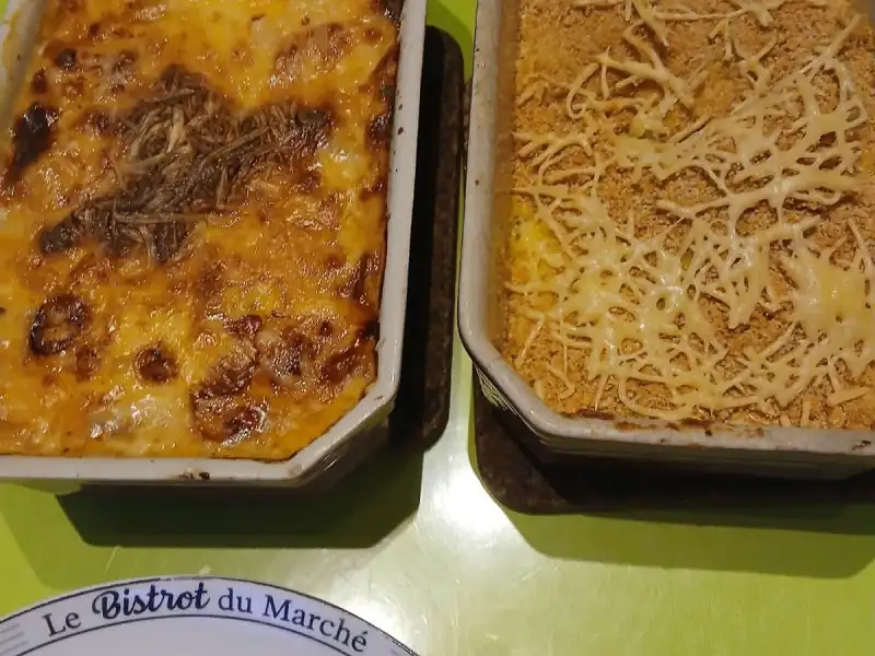 Cebola-roxa gratinada, com purê caseiro gratinado com farinha de rosca, servidos em duas travessas, sobre uma mesa verde.