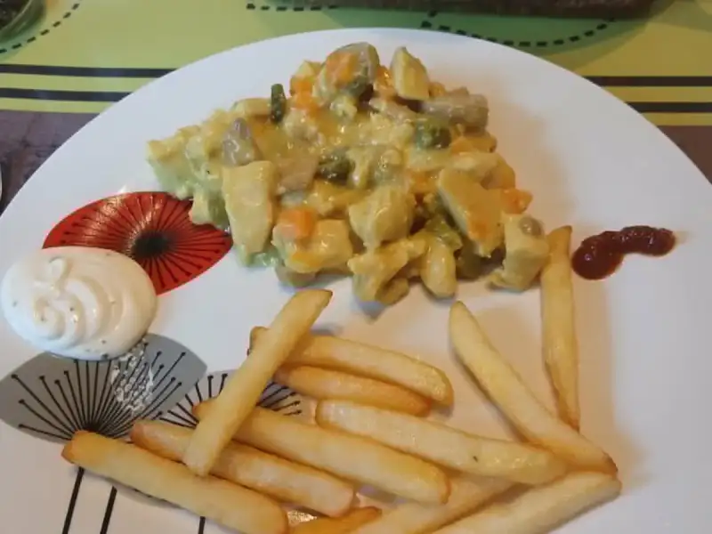 Vol-au-vent recheado com frango, cogumelos, cenoura e ervilhas, em molho de açafrão, servido com batatas fritas e maionese.